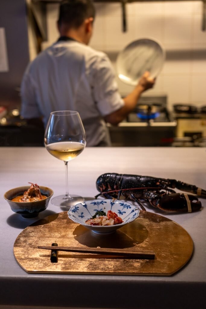 Plato y copa de vino blanco en la mesa de Soluna